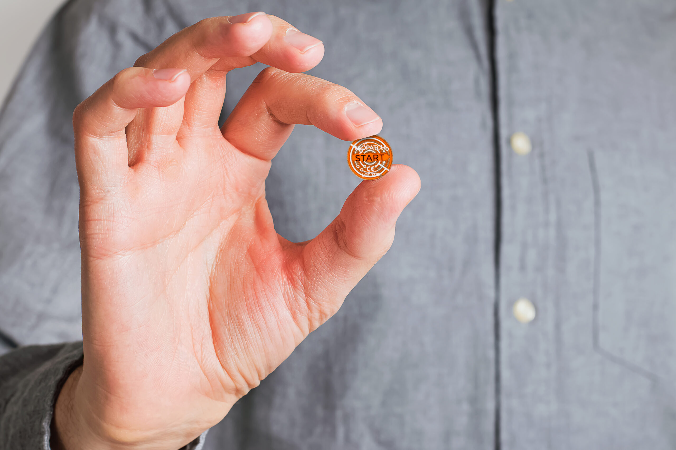 Close-up shot of male hand holding a white pill